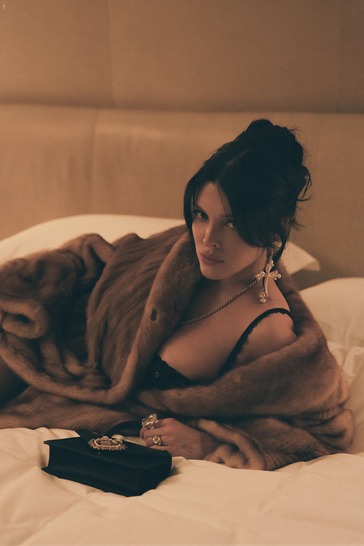 Sofía Gonet reclining in a mink coat beside a Dolce & Gabbana Devotion bag