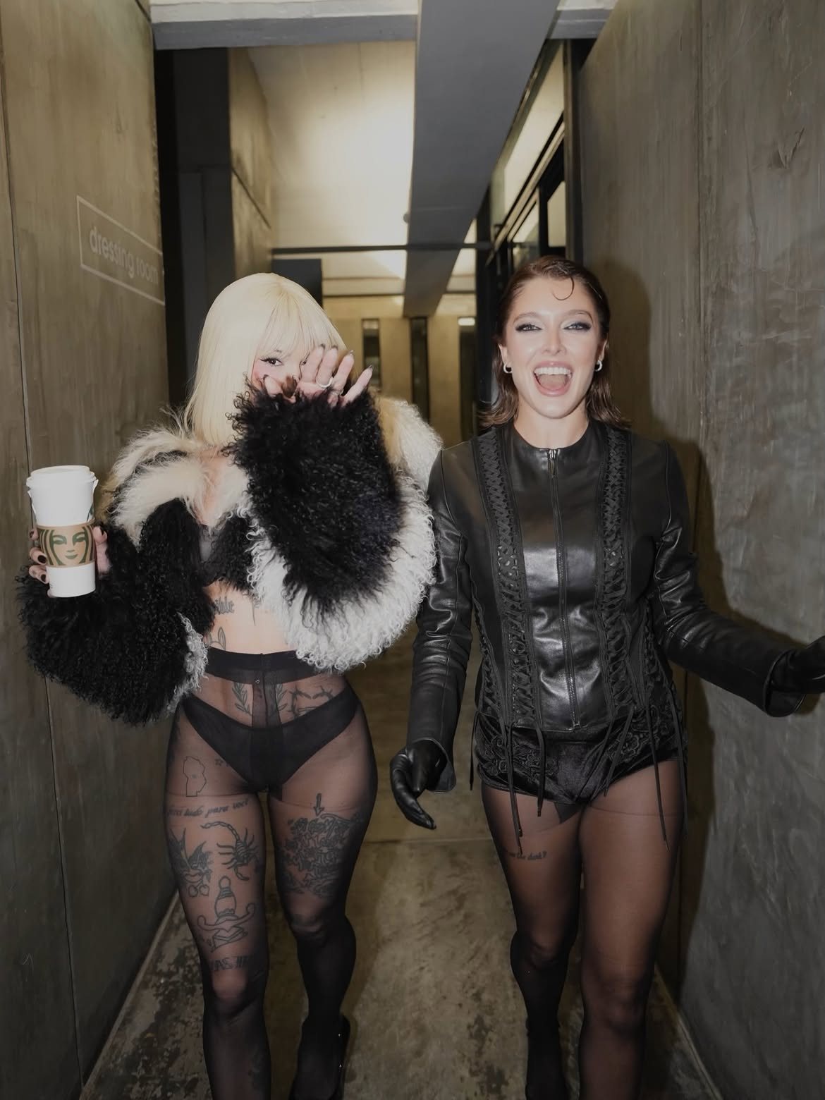 La Joaqui and Sofía Gonet walking down a backstage corridor, laughing
