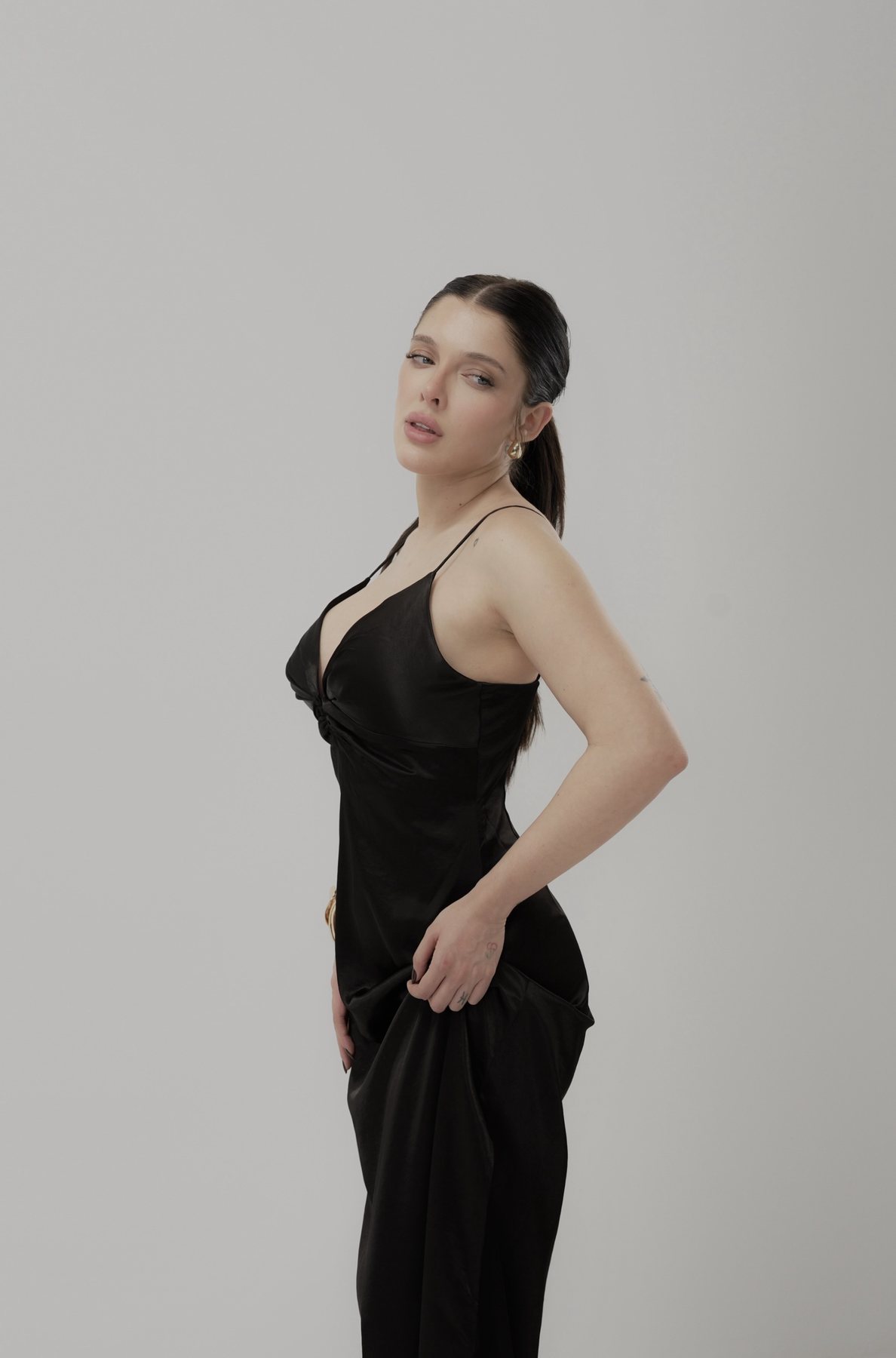 Sofía Gonet glancing back over her shoulder in the black slip dress