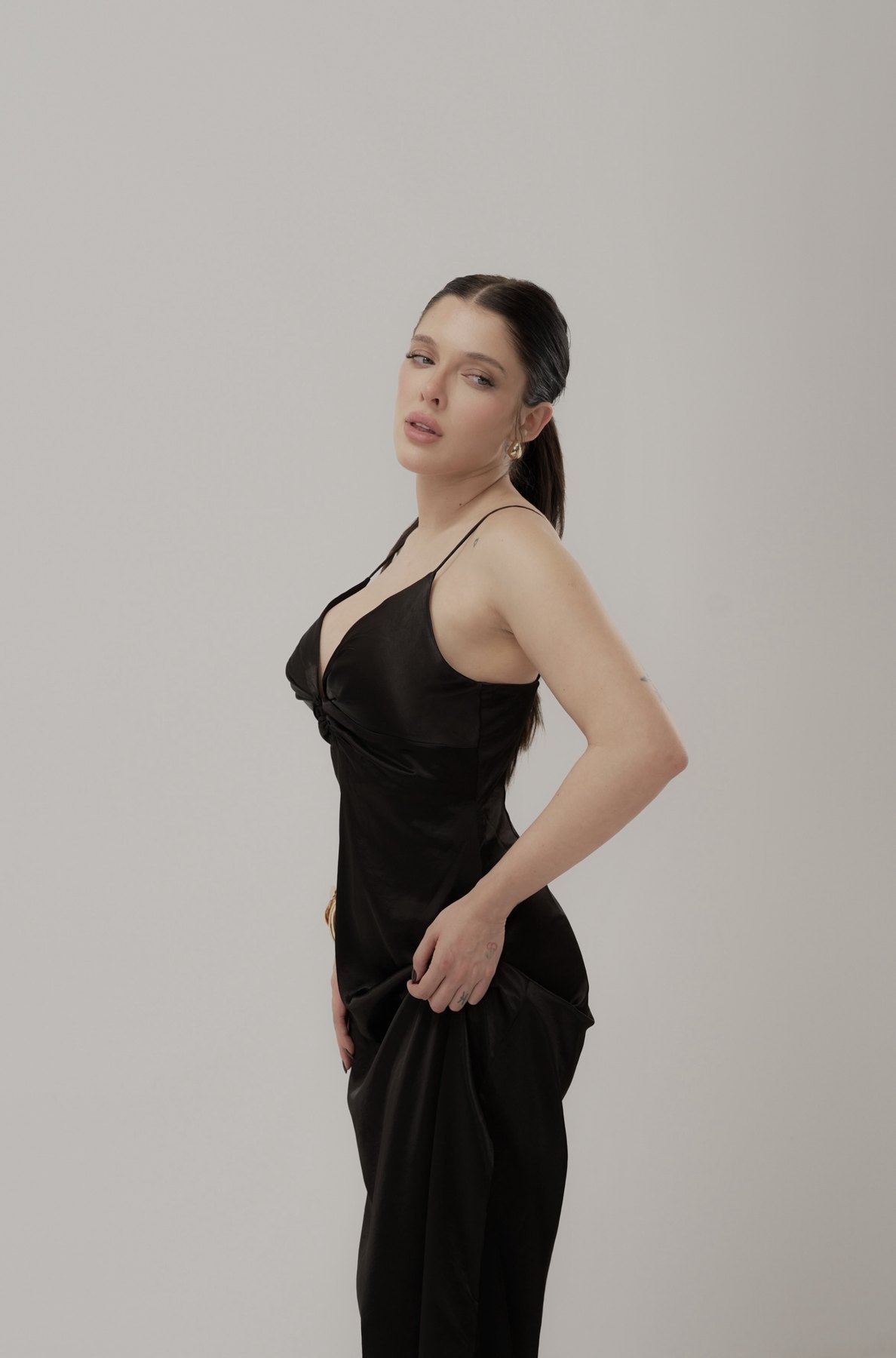 Sofía Gonet glancing back over her shoulder in the black slip dress