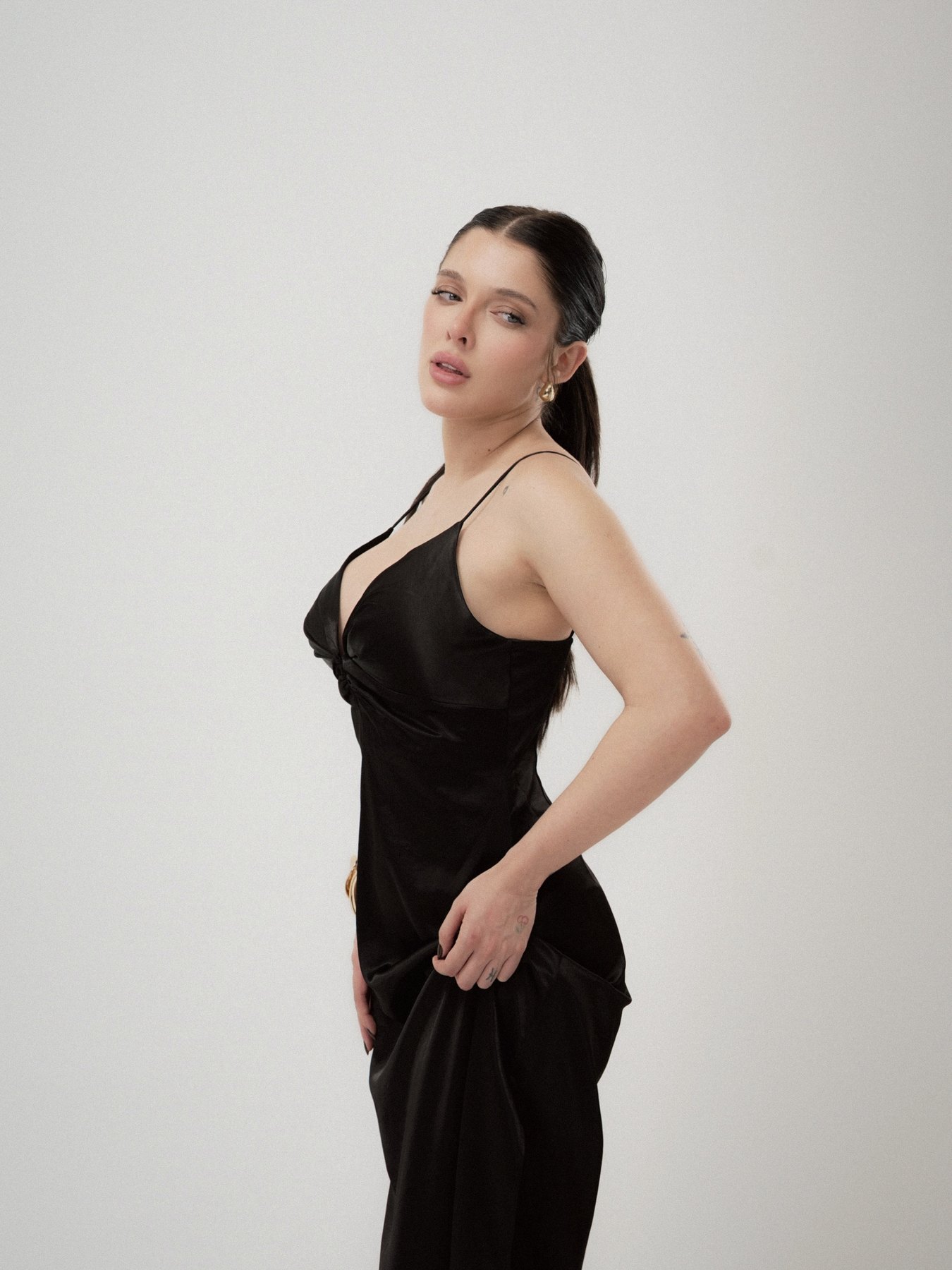 Sofía Gonet glancing back over her shoulder in black satin