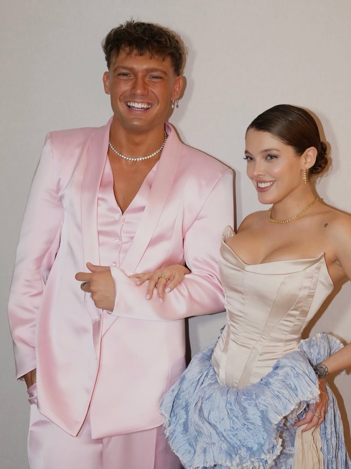 Sofía Gonet arm in arm with a companion in a pink satin suit, smiling
